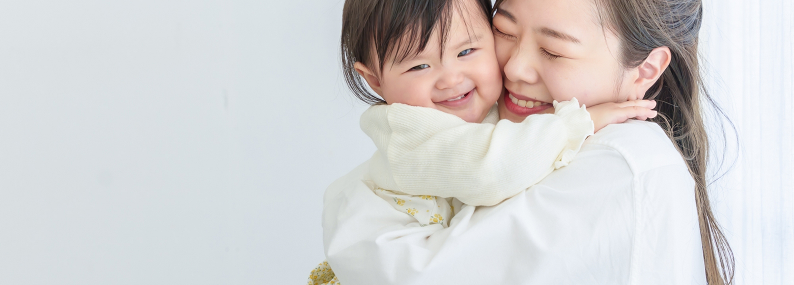 お母さんに抱っこされて笑顔を見せる子ども
